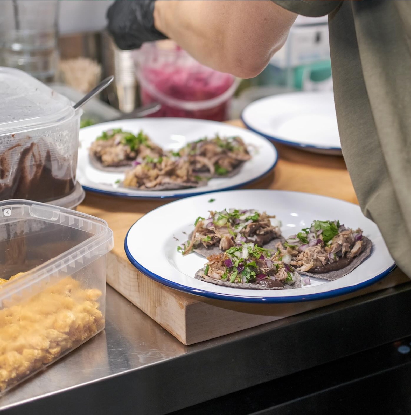 Plates of tacos being finished in the Hella kitchen